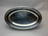 a silver plate on a white table with a white background