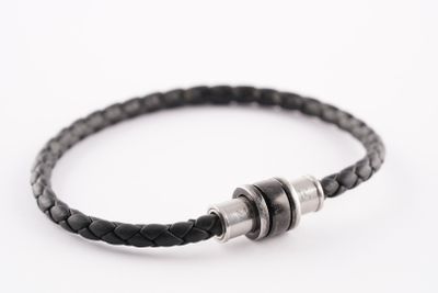 un gros plan sur un bracelet en cuir noir muni d'un fermoir en argent