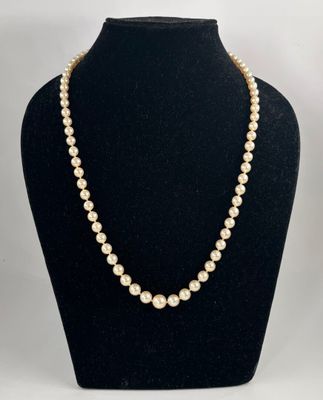 un collier de perles blanches sur un mannequin noir