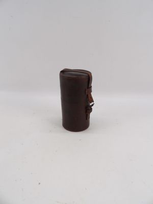 une petite tasse marron avec une anse, posée sur une surface blanche