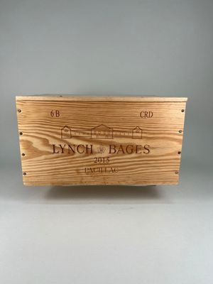une boîte en bois sur laquelle est collée une étiquette de vin, posée sur une table
