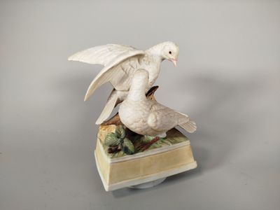 une figurine représentant un oiseau blanc perché sur un livre