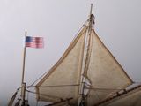 a small sail boat with a flag on the mast