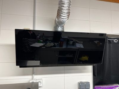 un téléviseur fixé au mur au-dessus de l'évier de la cuisine