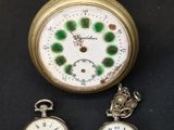 Trois types différents de montres de poche sont exposés sur un fond noir