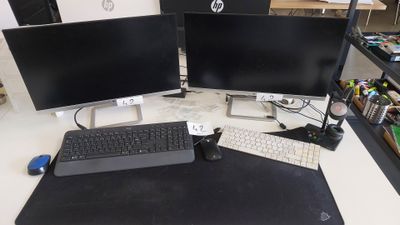 trois écrans d'ordinateur et un clavier posés sur un bureau