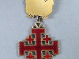 an image of a medal with a red cross on it