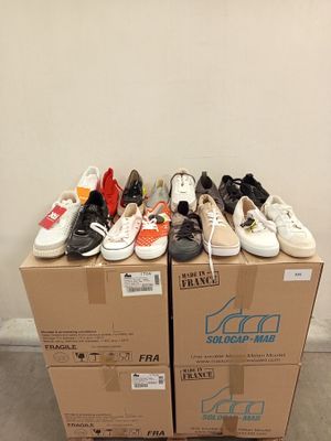 many pairs of shoes sitting on top of a cardboard box