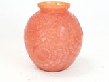 an orange vase sitting on a white surface