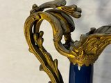 a blue vase with a gold decoration on it