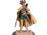 La figurine représentant un homme coiffé d'un chapeau et vêtu d'un manteau est posée sur un socle en bois.