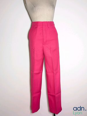 pink pants on a mannequin stand against a white wall