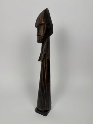 une statue en bois représentant une femme portant une capuche sur la tête
