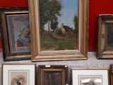 a lot of framed pictures on the floor next to a red wall