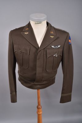 un uniforme militaire sur un mannequin, devant un fond gris