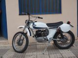 a white motorcycle parked on the sidewalk in front of a building