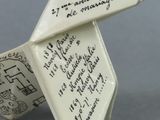 a white origami with writing on it on a gray surface