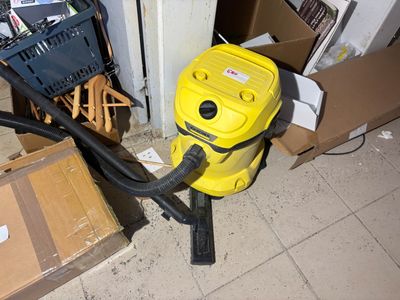 a yellow vacuum sitting on the floor next to a box