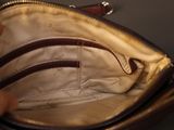 a person holding a purse that has a zipper on it
