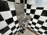 a black and white checkered wall with a sink in it