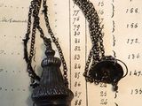un collier auquel est suspendue une clochette, posé sur une table