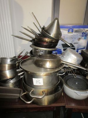 de nombreuses casseroles et poêles posées sur une table