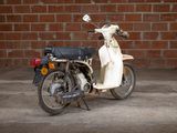 a motor scooter parked in front of a brick wall