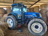 a blue tractor that is parked in a barn