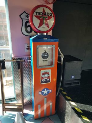 an orange and blue gas pump sitting in a room next to a window