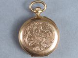 an image of a gold pocket watch sitting on top of a blue surface