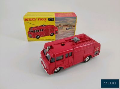 un camion de pompiers rouge en jouet à côté d'une boîte dans son emballage