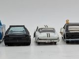 several toy cars are lined up in a row on a white surface