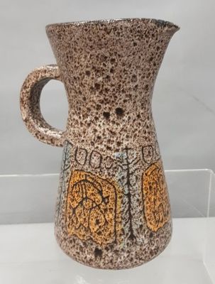 un vase marron et noir exposé dans une vitrine