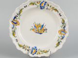 an antique plate with blue and yellow flowers on it