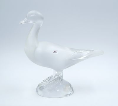 a glass duck that is sitting on top of a base