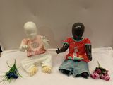 two figurines sitting on a table with flowers