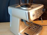 a coffee maker on a table with a bowl on top of it