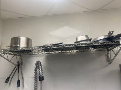 une étagère avec des casseroles et des poêles dans une cuisine