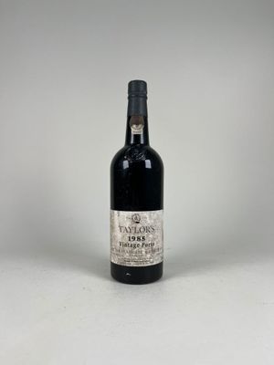 an old bottle of wine sitting on top of a white table