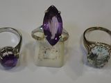 three different rings and a ring with a purple stone