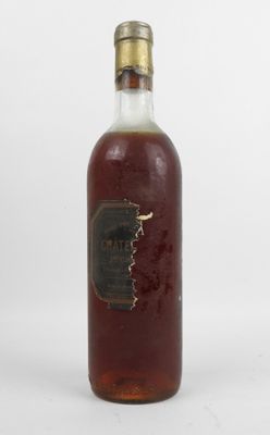 une vieille bouteille d'alcool posée sur une surface blanche