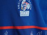 the shirt is blue with red and white stripes and a star on the front