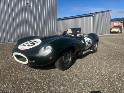 une voiture de course verte garée devant un immeuble