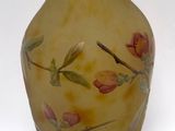 a yellow vase with flowers painted on it on a white background