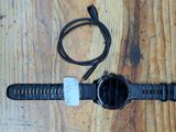 une montre branchée sur un chargeur posé sur une table en bois