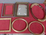 de nombreux cadres posés sur une table recouverte d'une nappe rouge