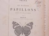 un livre orné d'un papillon, posé sur une table