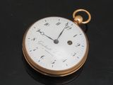 a close up of a gold pocket watch on a table