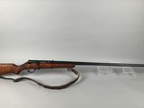 a rifle on a white background with a brown strap