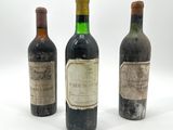 trois bouteilles de vin posées les unes à côté des autres sur une surface blanche